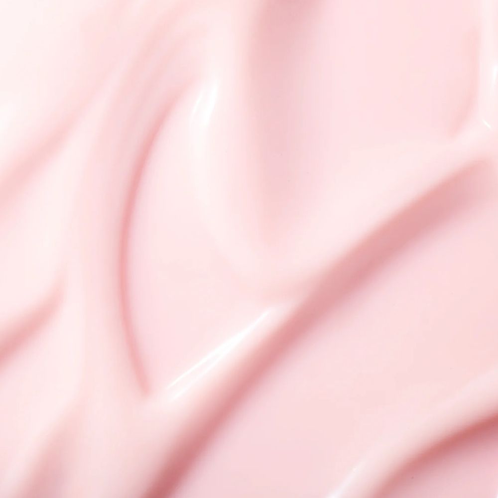 Primo piano di una crema rosa liscia. La crema ha una superficie lucida e una consistenza ondulata.