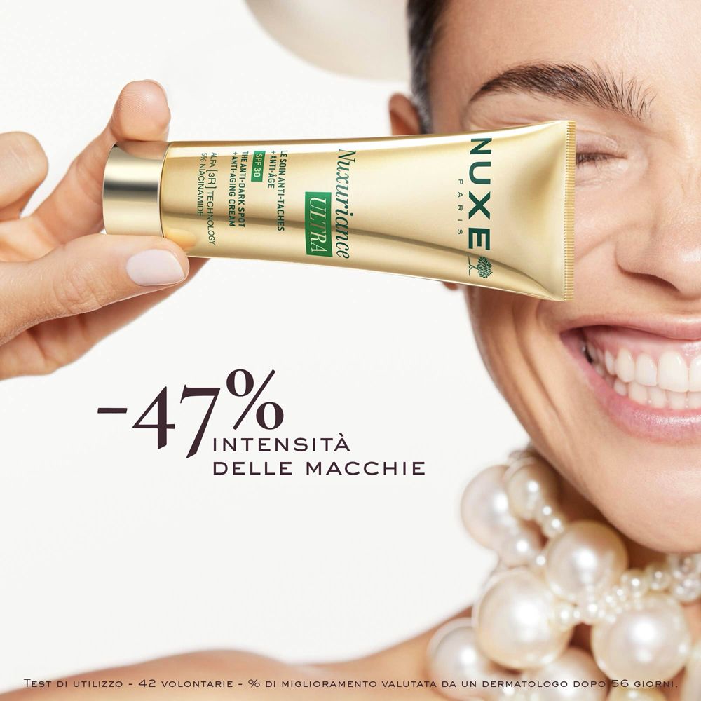 Donna tiene tubo Nuxe. Testo: -47% intensità delle macchie. Nome prodotto Nuxuriance Ultra. SPF30.