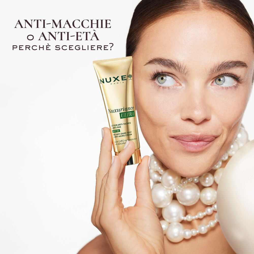 Donna con tubo Nuxe. Testo: Anti-macchie o anti-età? Nome prodotto Nuxuriance Ultra. SPF30.