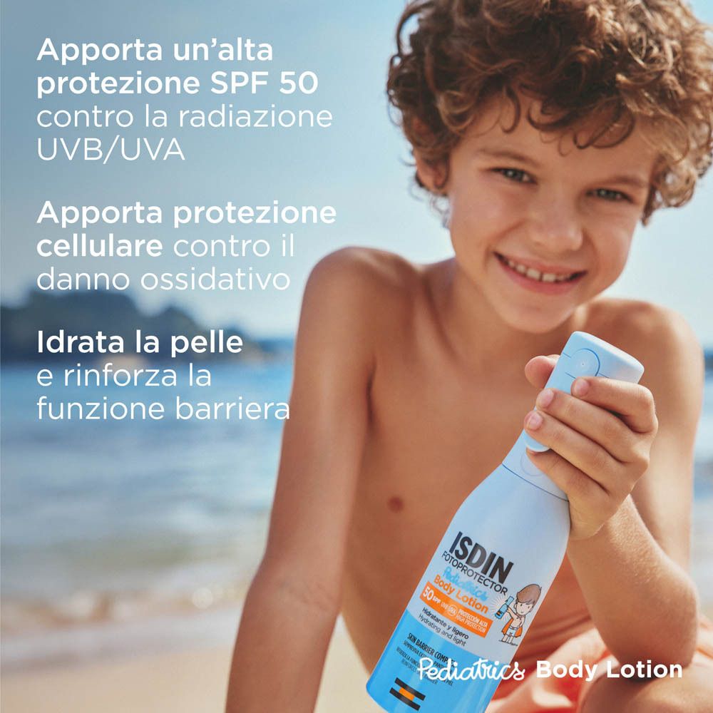 Bambino tiene in mano un flacone spray blu chiaro con logo ISDIN. Testo: SPF 50, protegge da UVB/UVA, idrata.