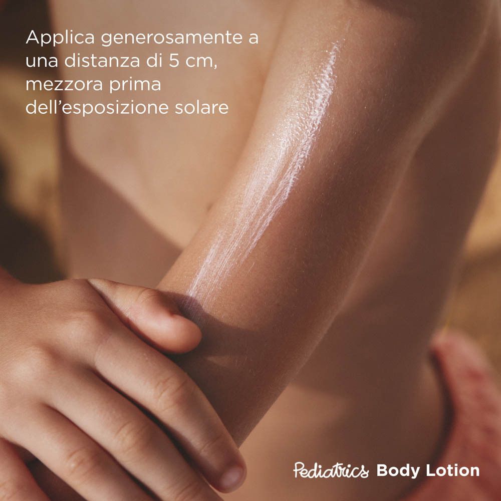 Bambino con crema solare sul braccio. Testo: Applicare generosamente, 5 cm di distanza, 30 min prima esposizione.