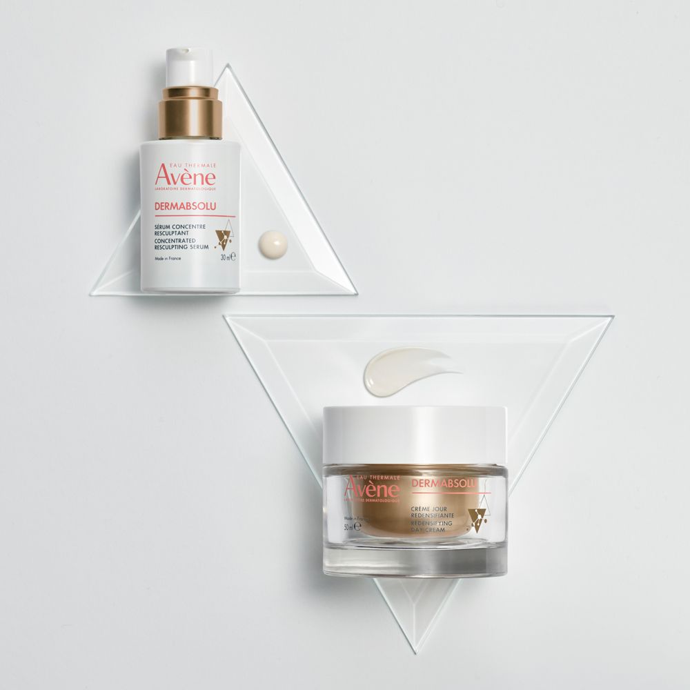 Siero e crema giorno Avène Dermabsolu su triangoli di vetro. Traccia di crema.