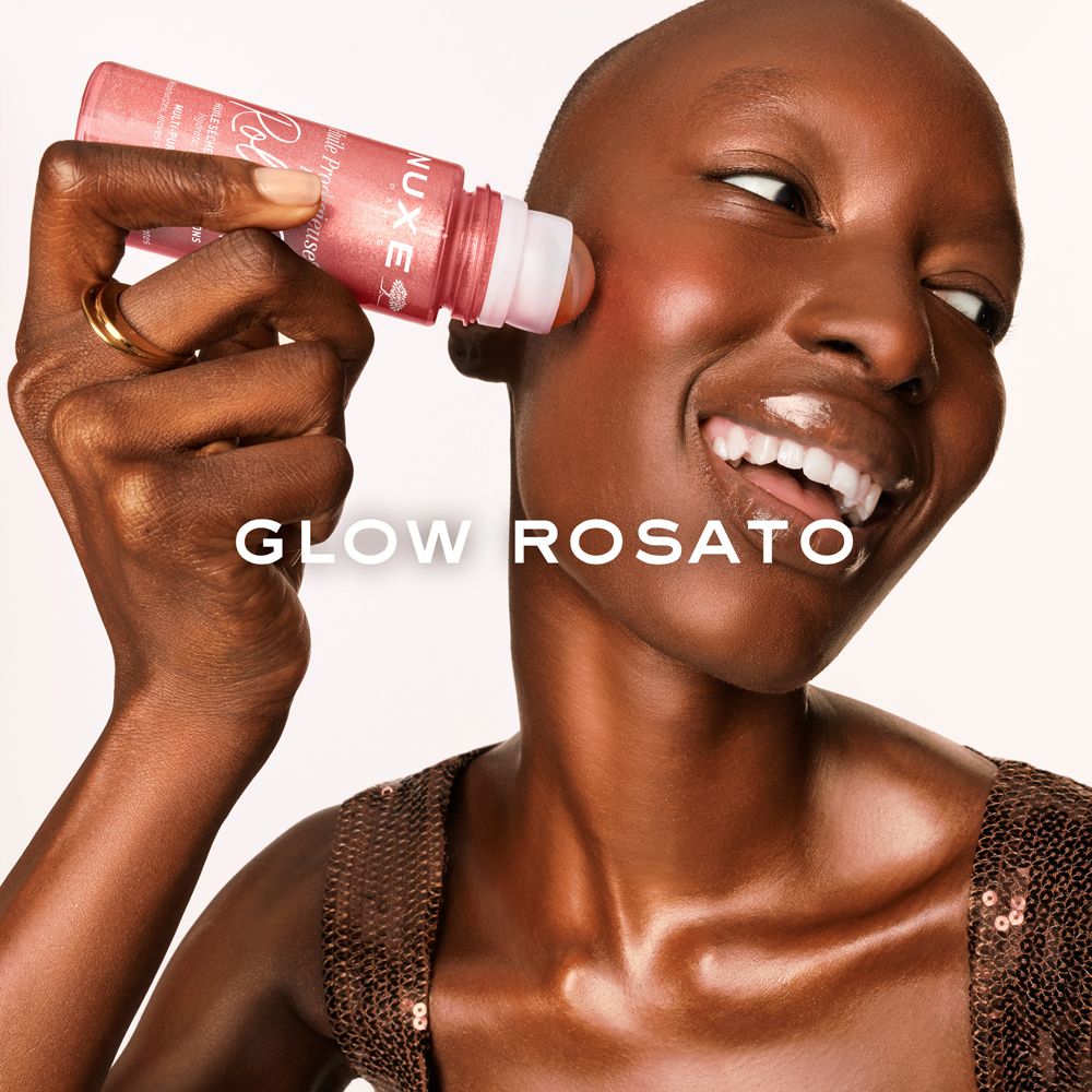 Donna con roll-on sullo zigomo. Prodotto rosa. Anello dorato. Testo.