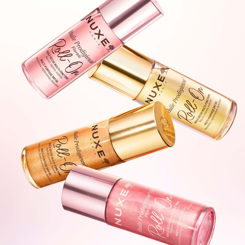 Quattro Nuxe Huile Prodigieuse Florale Roll-On. Sfondo rosa. Diversi colori.