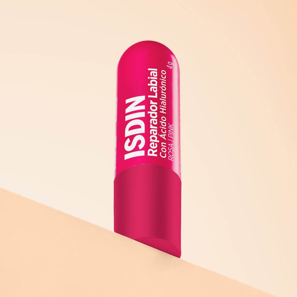 Stick riparatore labbra rosa. Forma cilindrica, rosa. Logo ISDIN e nome del prodotto in bianco.