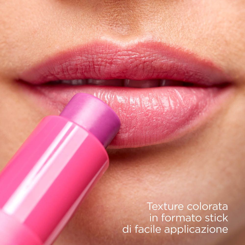 Labbra con rossetto rosa. Prodotto in uso. Testo: Texture in formato stick di facile applicazione.