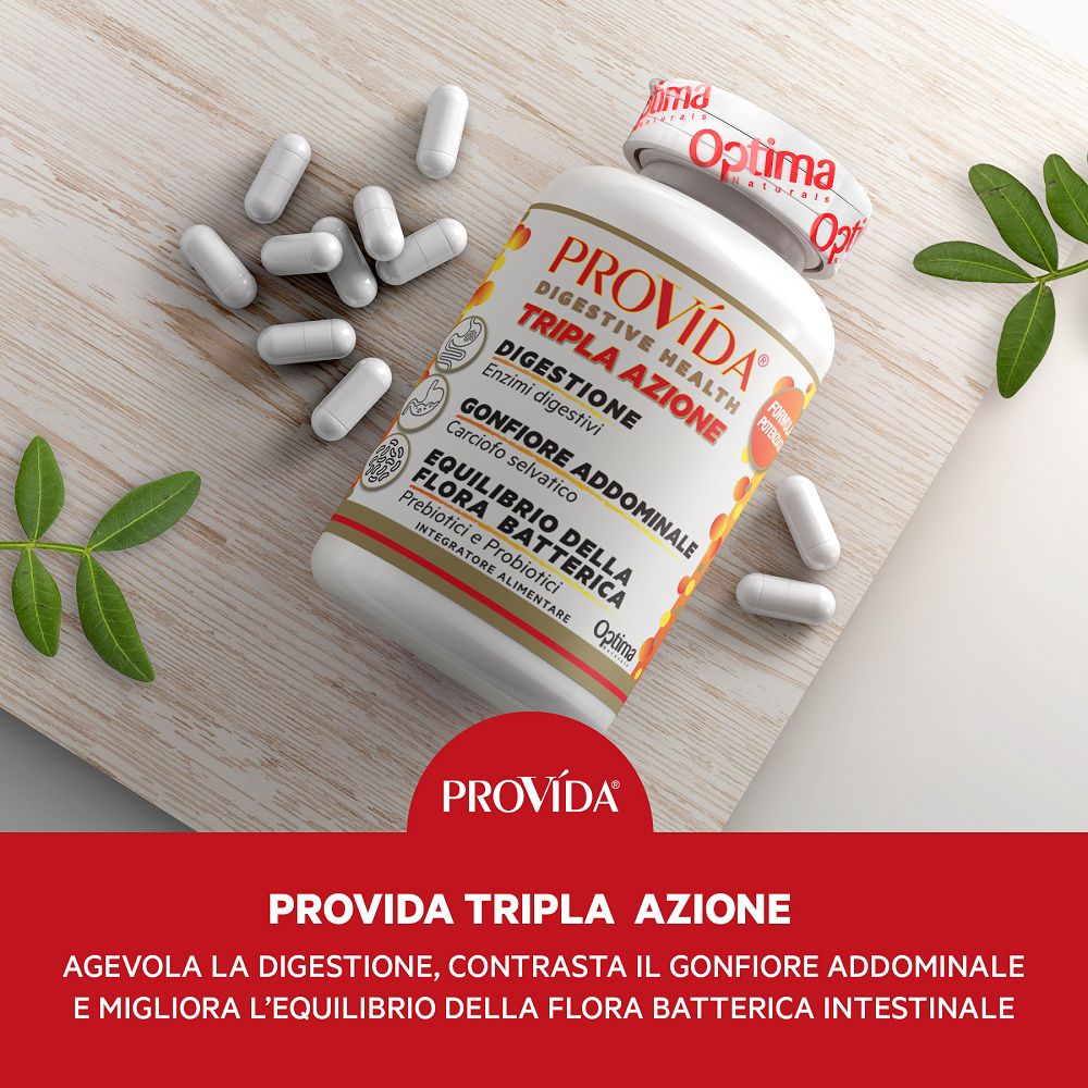 Barattolo Provida® Tripla Azione con capsule sparse su base di legno, con foglie verdi.