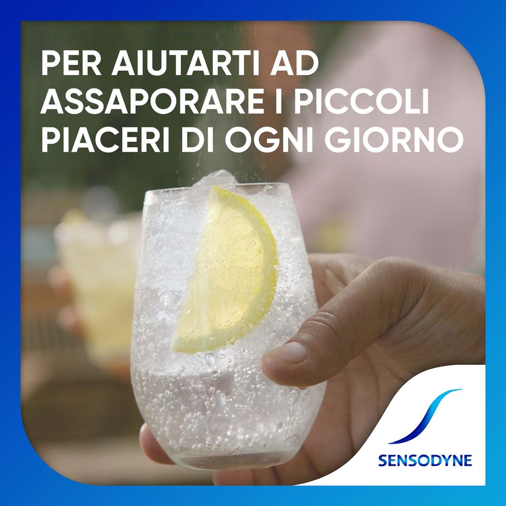 Bicchiere con cubetti di ghiaccio e fetta di limone, tenuto in mano. Logo Sensodyne.