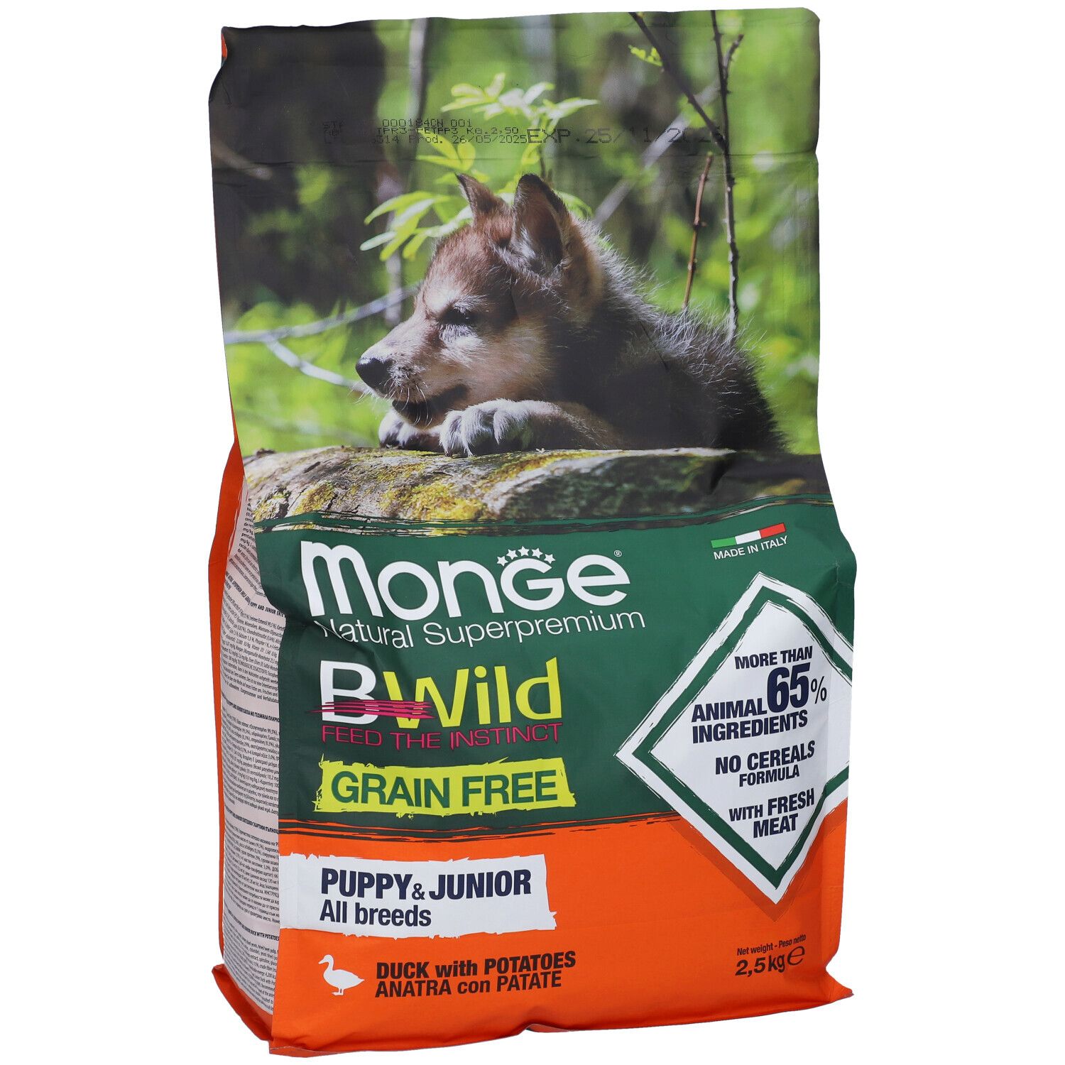 Sacchetto di cibo per cani con immagine di cucciolo. Scritta: Monge Bwild Grain Free Puppy & Junior. Contiene il 65% di ingredienti animali, senza cereali.
