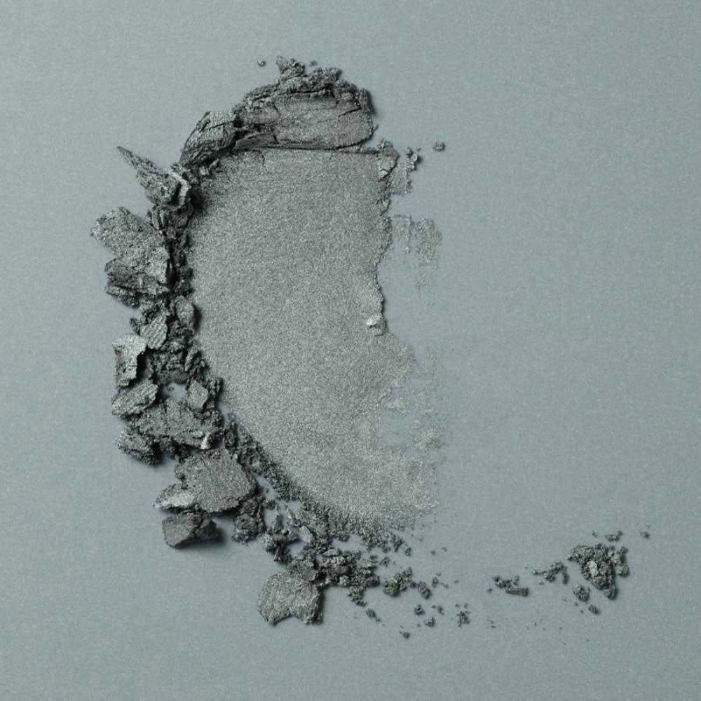 Mucchio di ombretto verde. Su sfondo grigio.