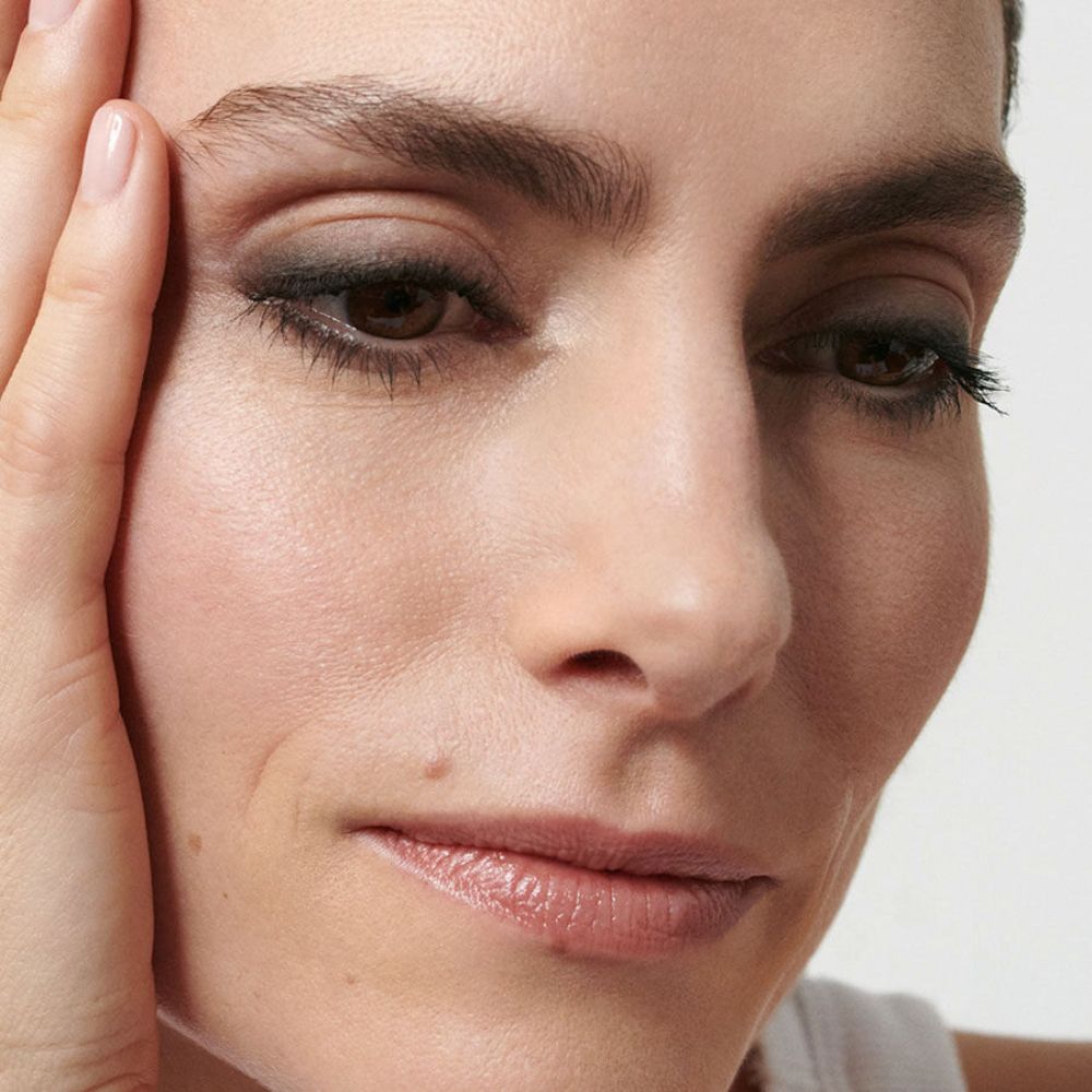 Primo piano di una donna con occhi truccati. Colori scuri di ombretto.