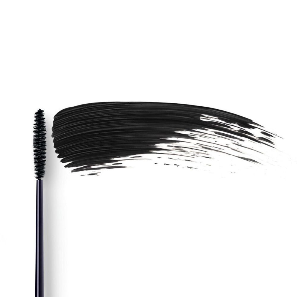Spazzola di mascara nero con traccia di mascara nero su sfondo bianco.
