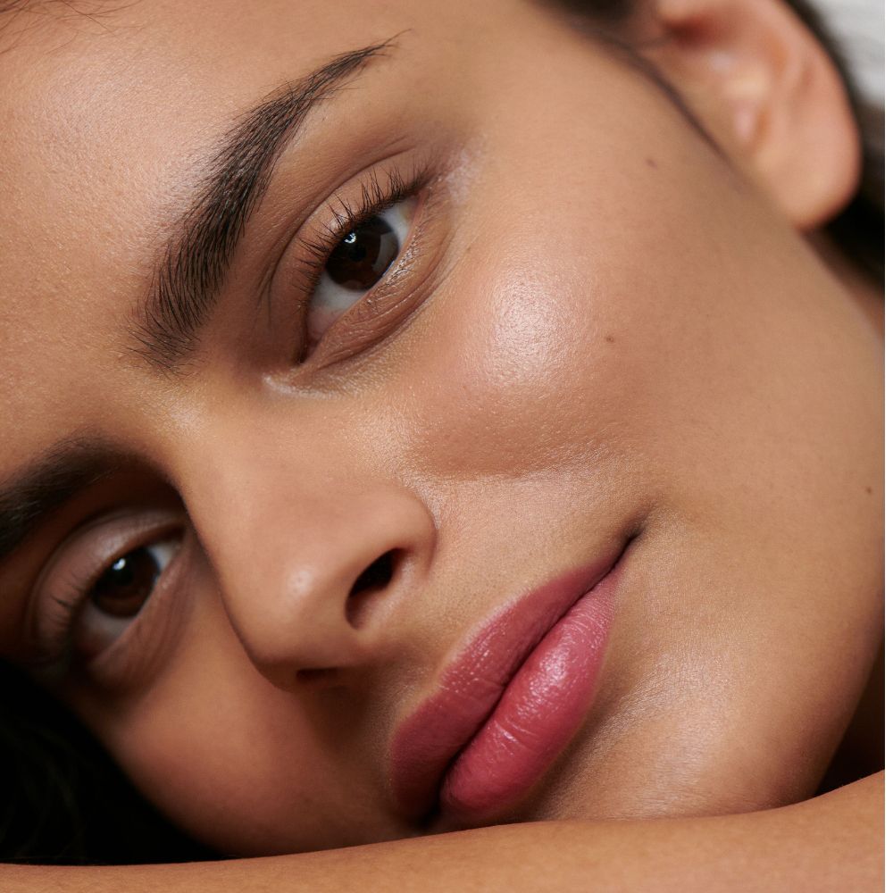 Primo piano di un viso con rossetto. Carnagione, sopracciglia e occhi scuri.