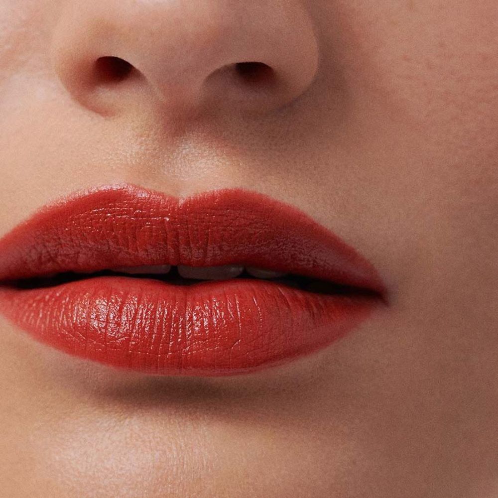 Primo piano di labbra con rossetto rosso. Pelle intorno alle labbra.