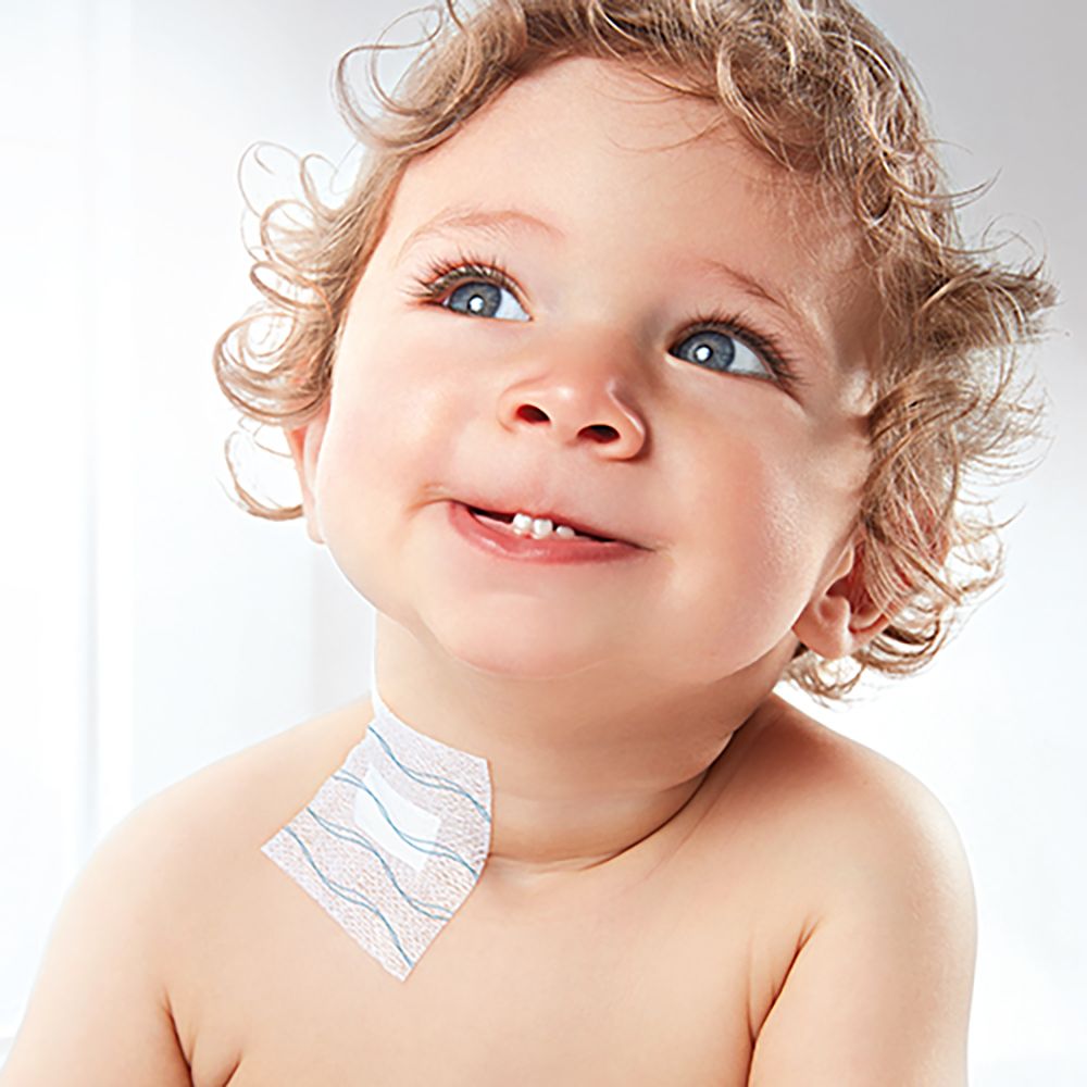 Un bambino con un cerotto sul collo. Il cerotto è bianco con linee blu ondulate.
