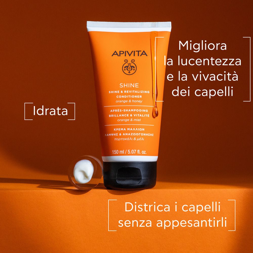 Tubo arancione con tappo bianco. Scritta: APIVITA SHINE Revitalisierender Conditioner. Testo: Idratata, Districa i capelli senza appesantirli.