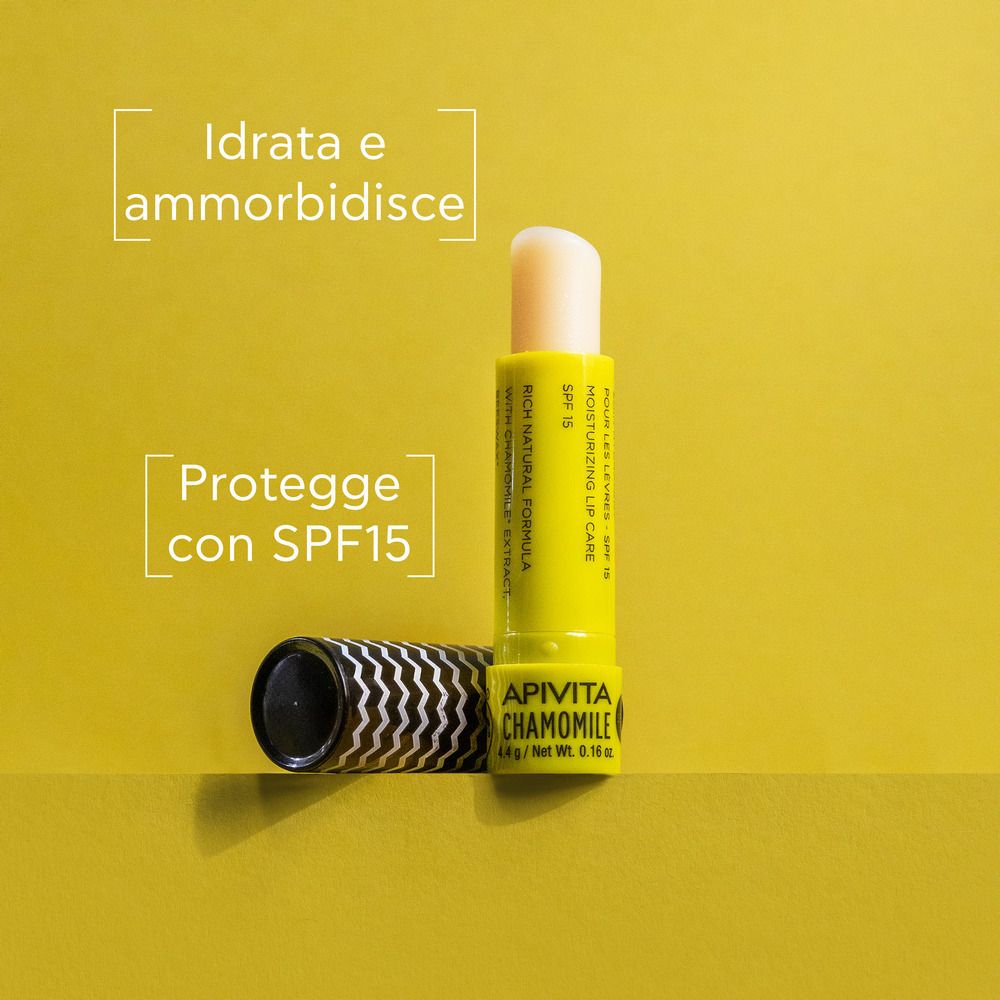 Balsamo per labbra con cappuccio aperto. Astuccio giallo, rossetto bianco. Testo: APIVITA CHAMOMILE, SPF 15.