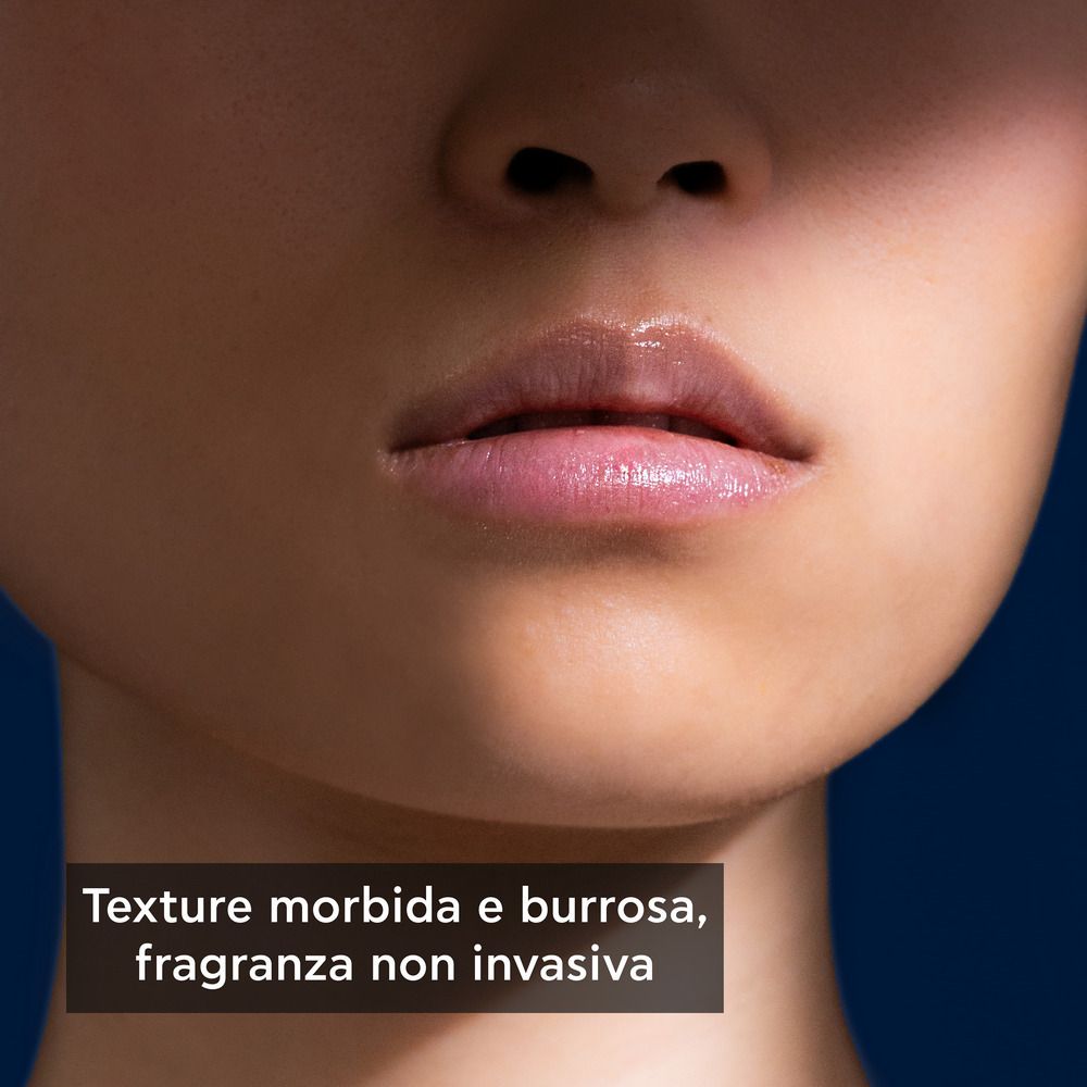 Primo piano delle labbra. Testo: Texture morbida e burrosa, fragranza non invasiva.