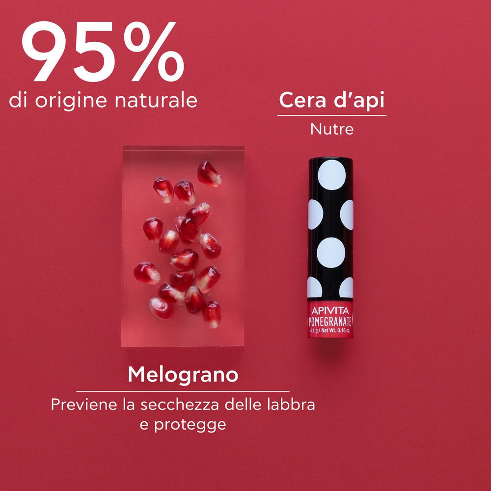 Balsamo labbra accanto a semi di melograno e testo. 95% di origine naturale. La cera d'api nutre.