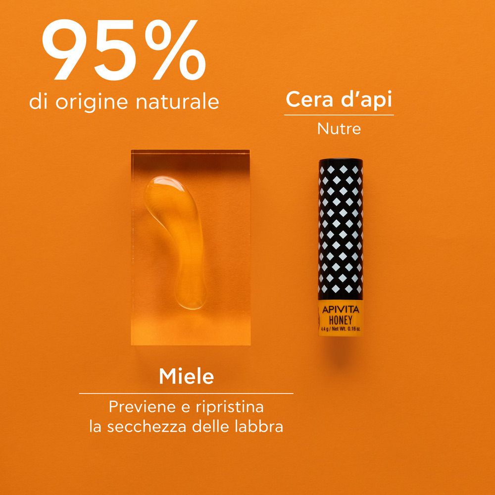 Balsamo labbra accanto a miele e cera d'api. Sfondo arancione. Testo: 95% di origine naturale.