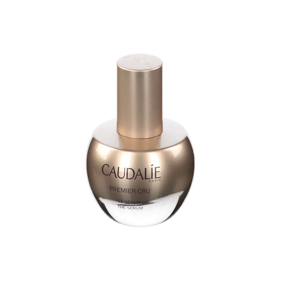 Flacone di siero. Flacone dorato con scritta CAUDALIE Premier Cru. Sfondo bianco.