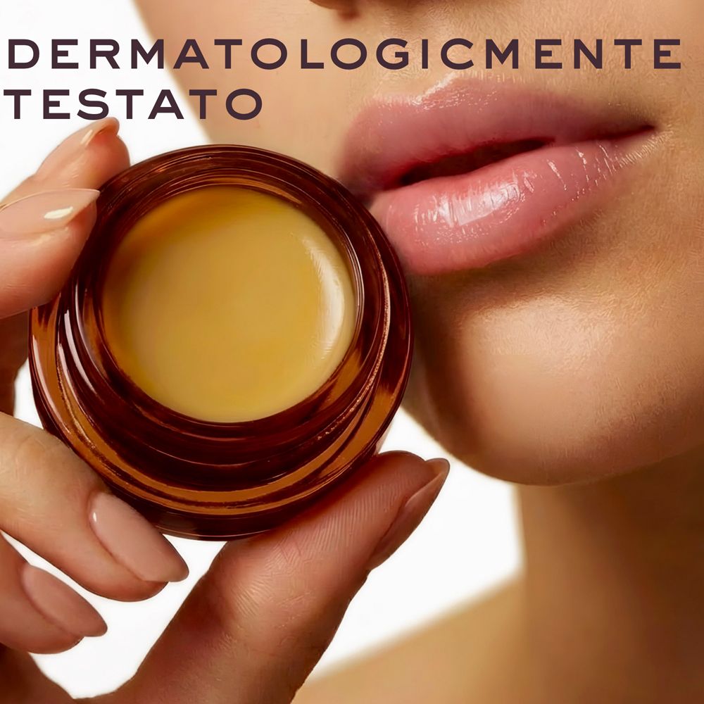 Mano che tiene un vasetto aperto di balsamo labbra Nuxe Rêve de Miel.
