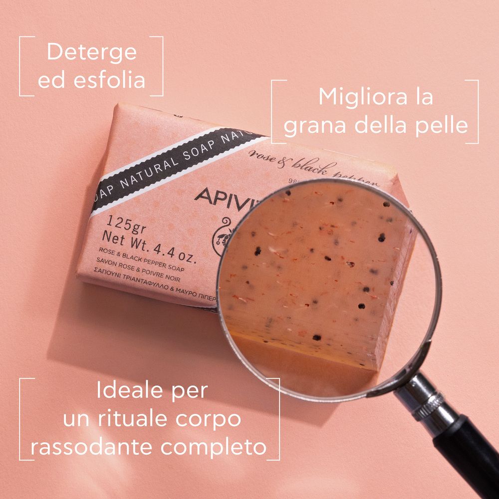 Sapone rosa e pepe nero. Primo piano con lente d'ingrandimento. Testi: Deterge ed esfolia, Migliora la grana della pelle.