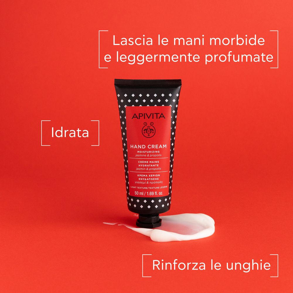 Tubo su sfondo rosso. Scritta: APIVITA, Hand Cream. Goccia di crema accanto. Testo: Lascia le mani morbide.