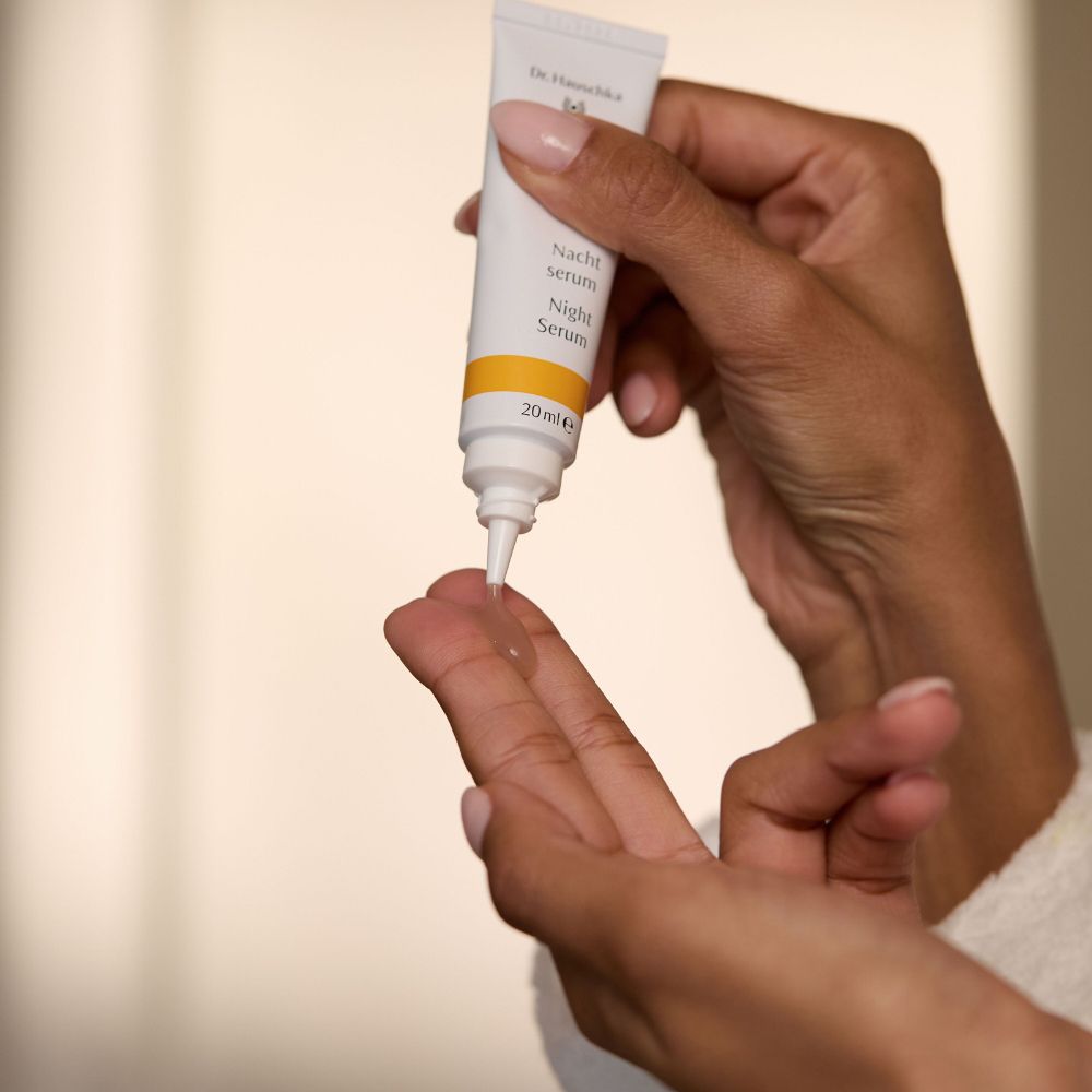 Mani che tengono il tubo. Il siero viene versato sul palmo. Scritta: Nacht Serum.