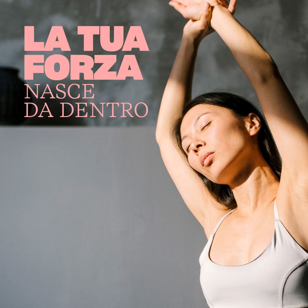 Giovane donna con occhi chiusi, che alza le braccia. Sfondo grigio. Testo in italiano.