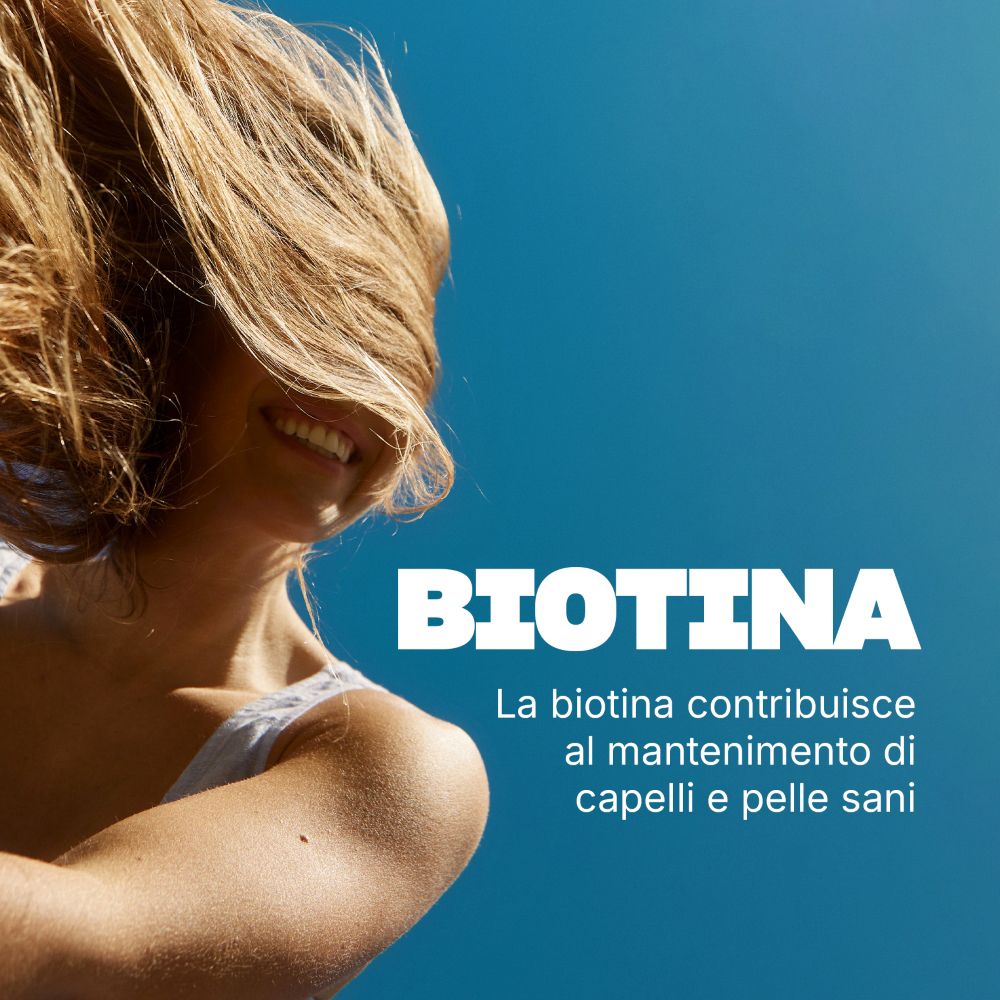 Donna con capelli lunghi e biotina: la biotina contribuisce a capelli e pelle sani.