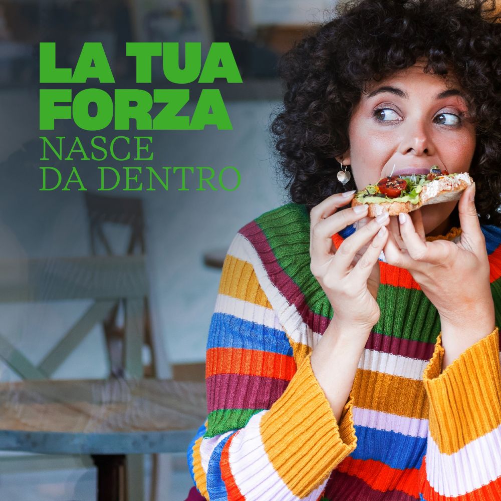 Donna che mangia pizza. Testo: La tua forza nasce da dentro.