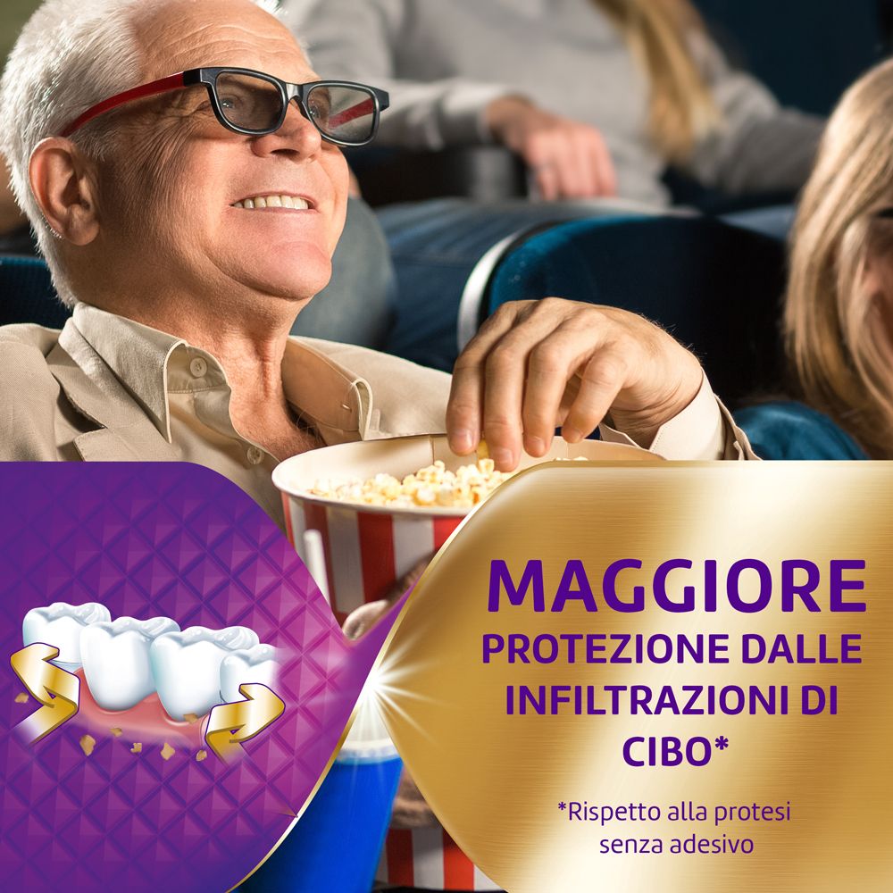 Uomo al cinema con pop-corn. Protesi dentaria con testo: Maggiore Protezione. Sfondo viola e oro.
