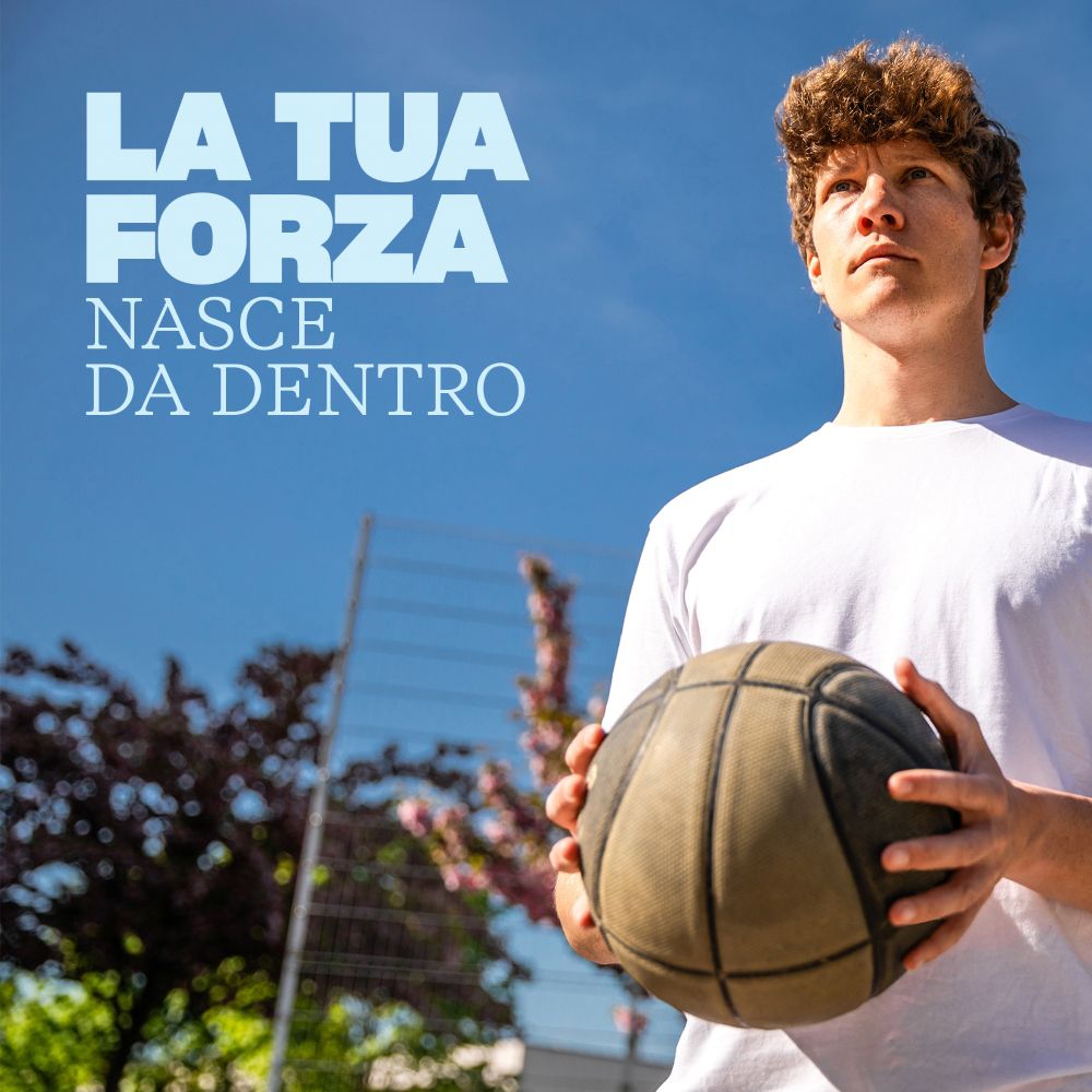 Un giovane con un pallone da basket, che simboleggia forza e vitalità.