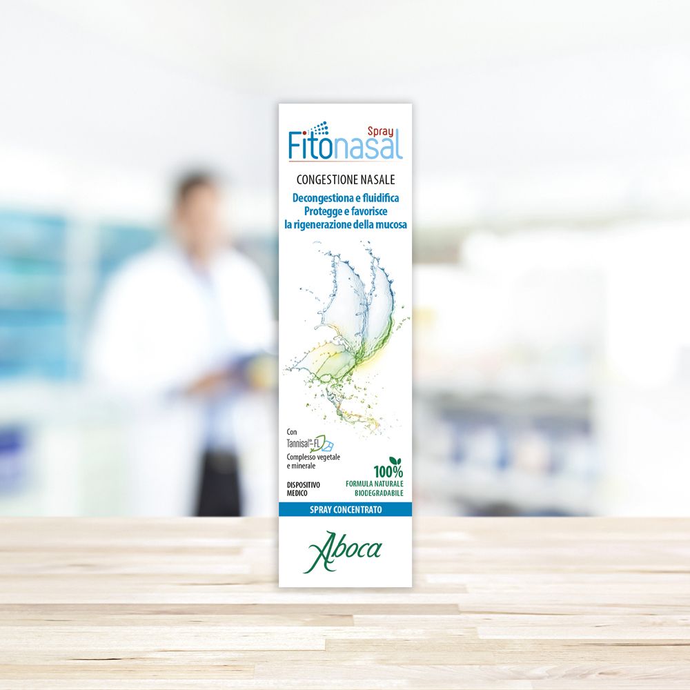 Confezione di Fitonasal Spray Concentrato. Bianca, con informazioni e logo. Sfondo sfocato.