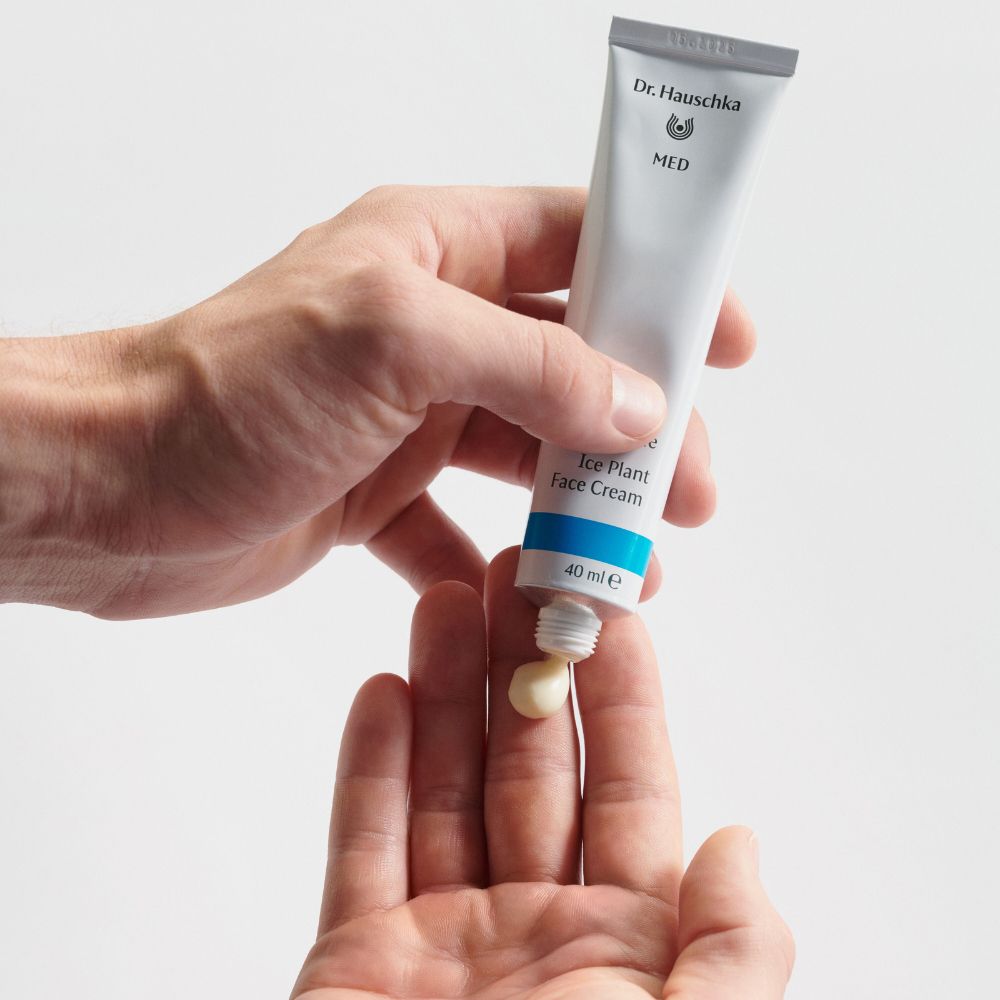 Mani che tengono un tubetto. La crema viene premuta sulle dita. Scritta: Dr. Hauschka, MED, Ice Plant Face Cream, 40 ml.