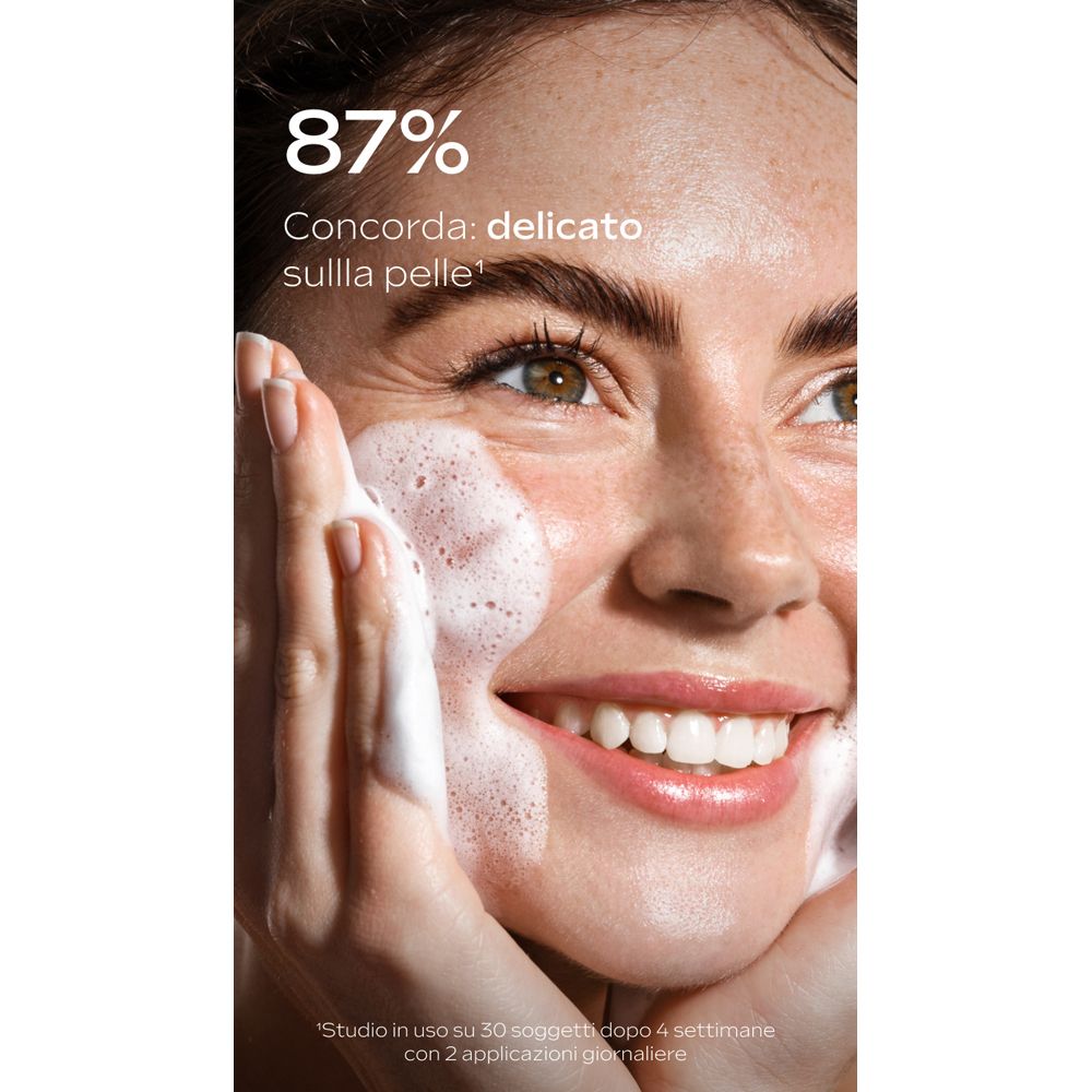 Primo piano di una donna che si lava il viso con la schiuma. Testo: 87% Concorada: delicato sulla pelle.