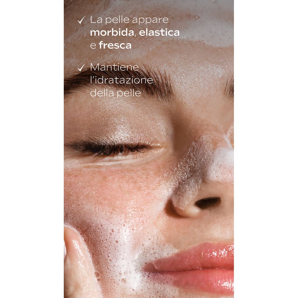 Primo piano di un viso con schiuma. Testo: La pelle appare morbida, elastica e fresca. Mantiene l'idratazione della pelle.