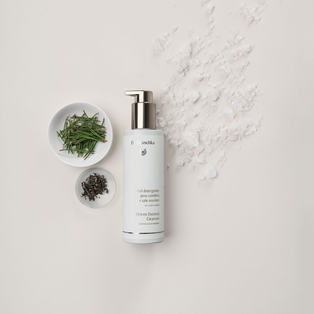Flacone bianco con erogatore argentato, accanto ciotole con aghi ed erbe. Testo: Gel detergente pino cembro e sale marino.