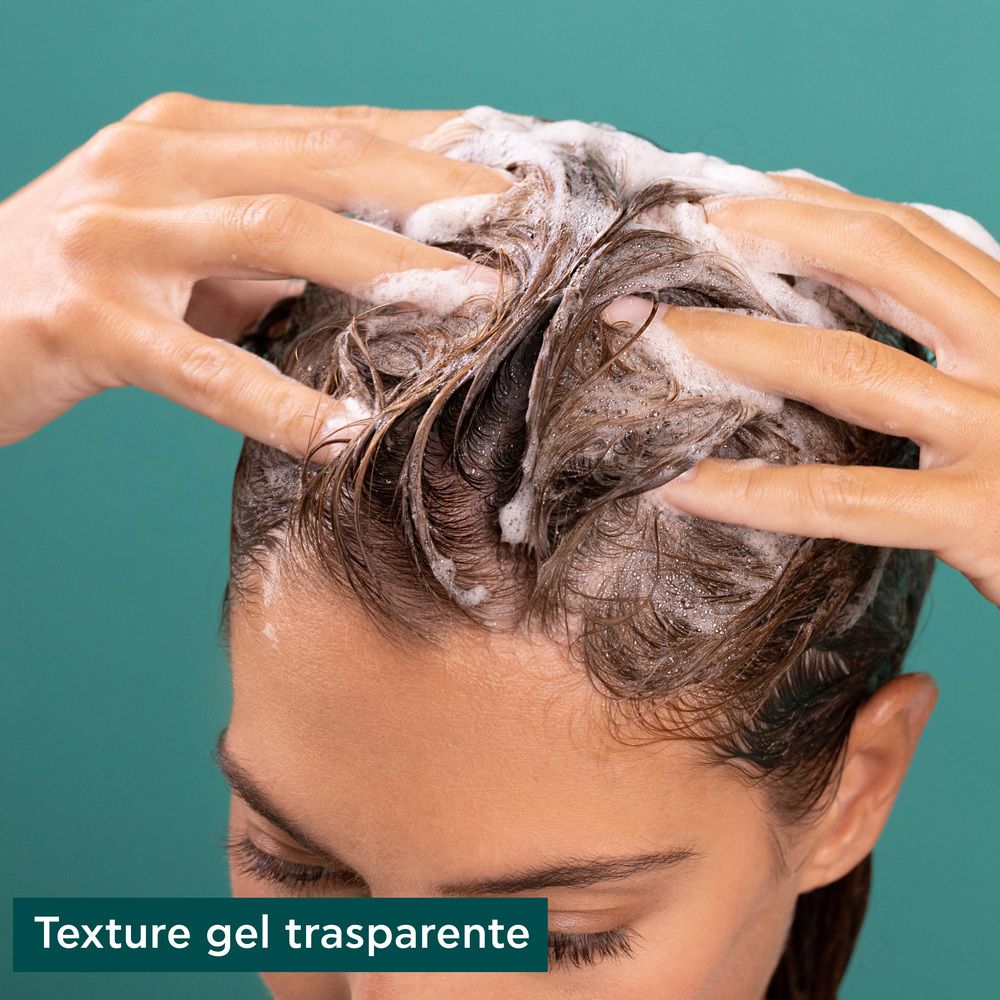Mani che lavano i capelli con schiuma. Testo: Texture gel trasparente.