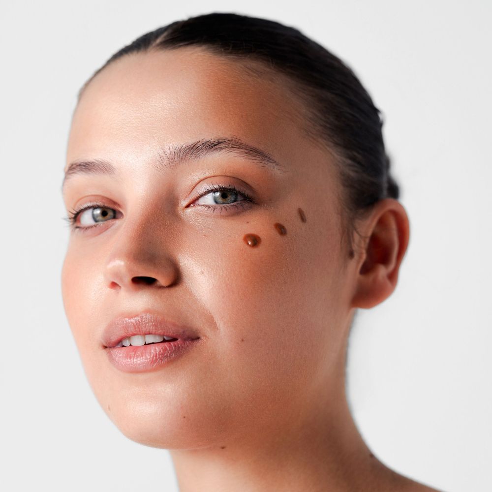 Viso con gocce marroni sulla pelle. Pelle chiara.