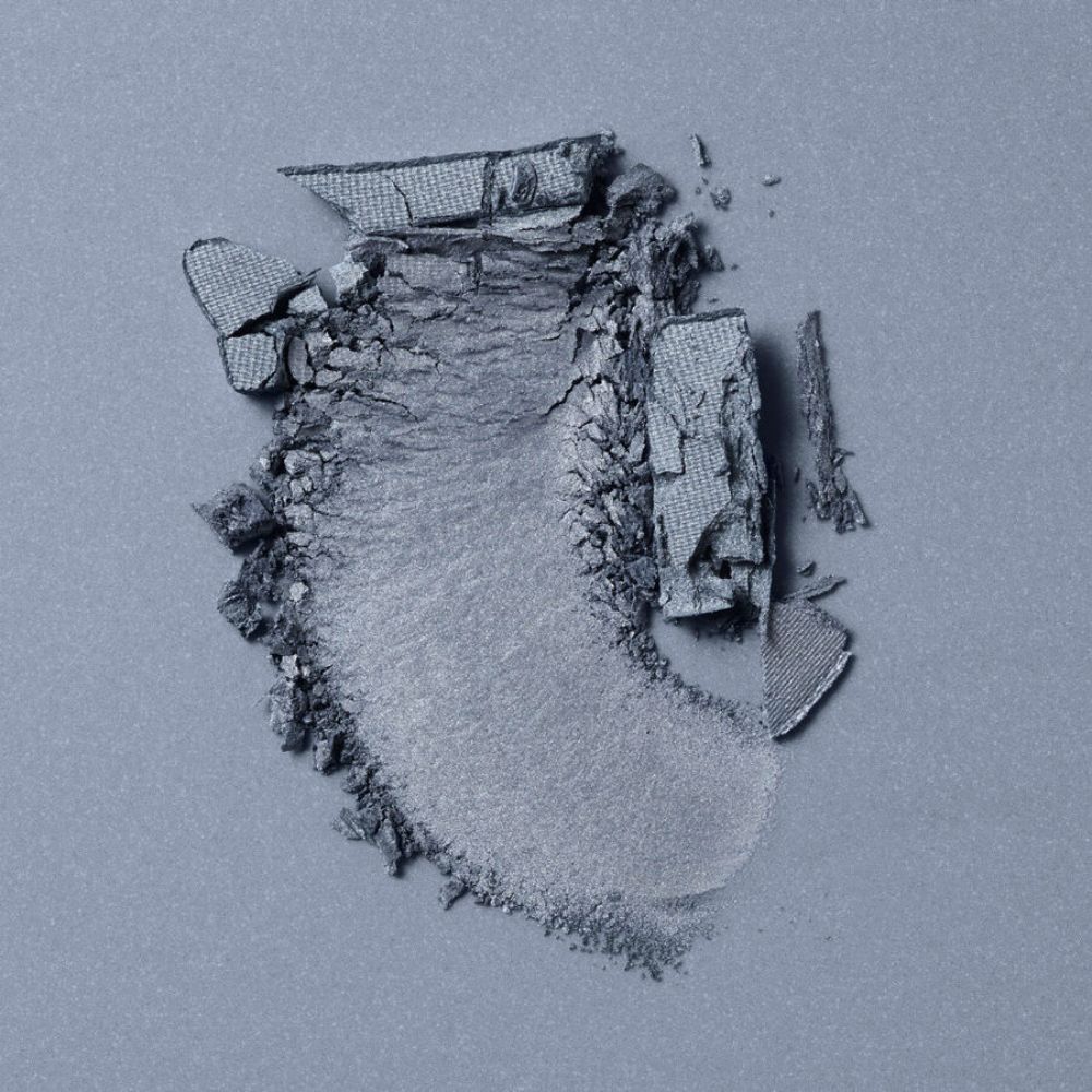 Campione di ombretto blu. Frammentato, con texture visibile.