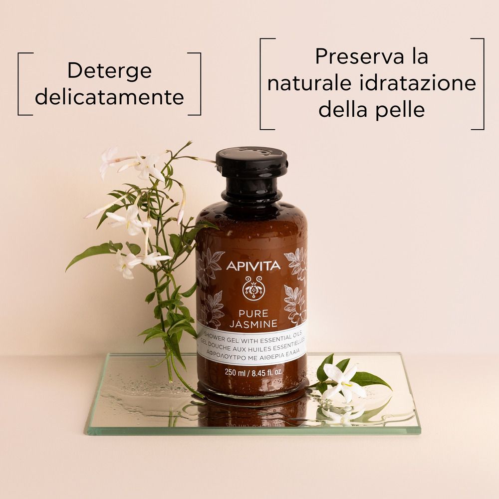 Flacone marrone con tappo nero su lastra di vetro. Scritta: APIVITA Pure Jasmine Gel doccia. Fiori di gelsomino.