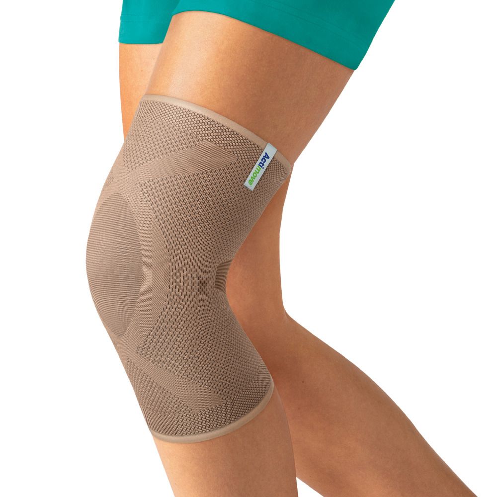 Persona che indossa Actimove Ginocchiera Elastica Chiusa Alla Rotula Xl beige. Ginocchiera sulla gamba. Marchio Actimove.