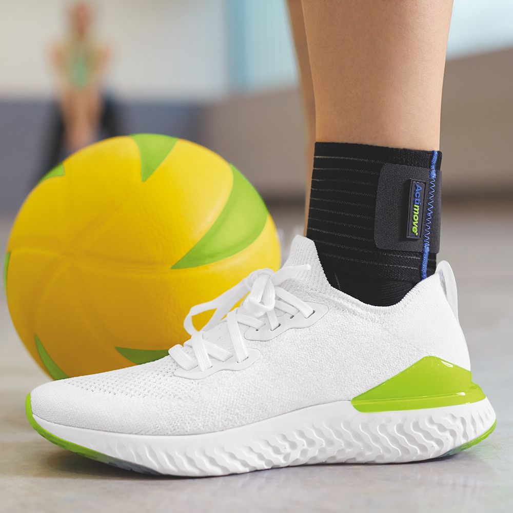 Cavigliera sul piede, indossata con scarpa sportiva bianca. Pallone giallo sullo sfondo. Logo Actimove.