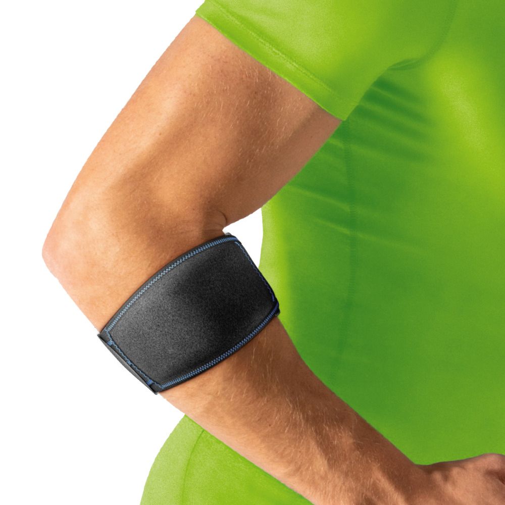 Un braccio con fascia per gomito Actimove nera. Cucitura blu. Il braccio è in una maglietta verde.
