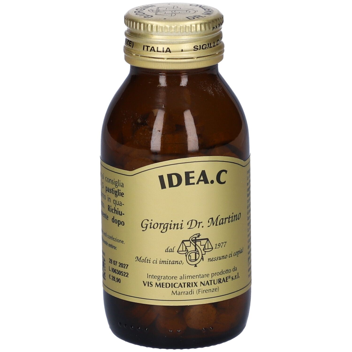 Flacone di vetro marrone con tappo dorato. Etichetta con nome del prodotto e testo. Compresse visibili.