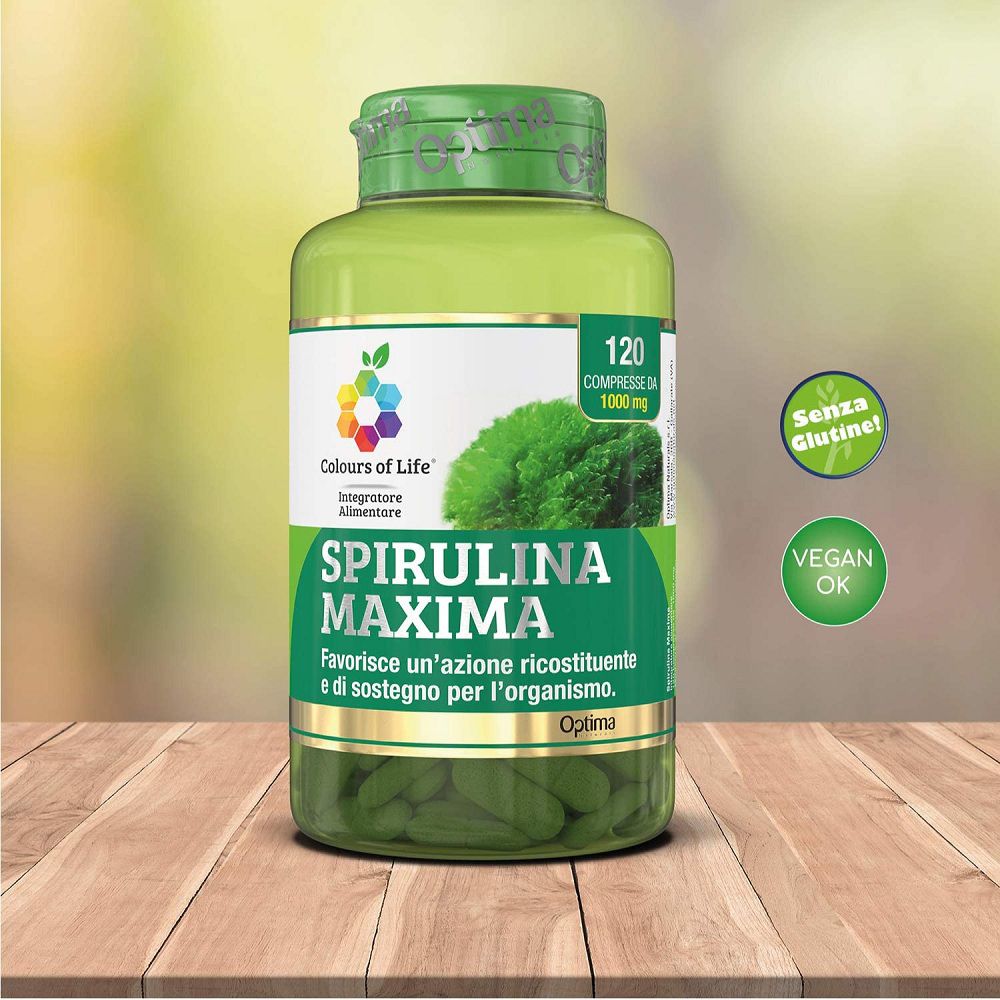 Barattolo verde Optima Spirulina Maxima su tavolo di legno, con sigilli "Senza Glutine" e "Vegan OK".