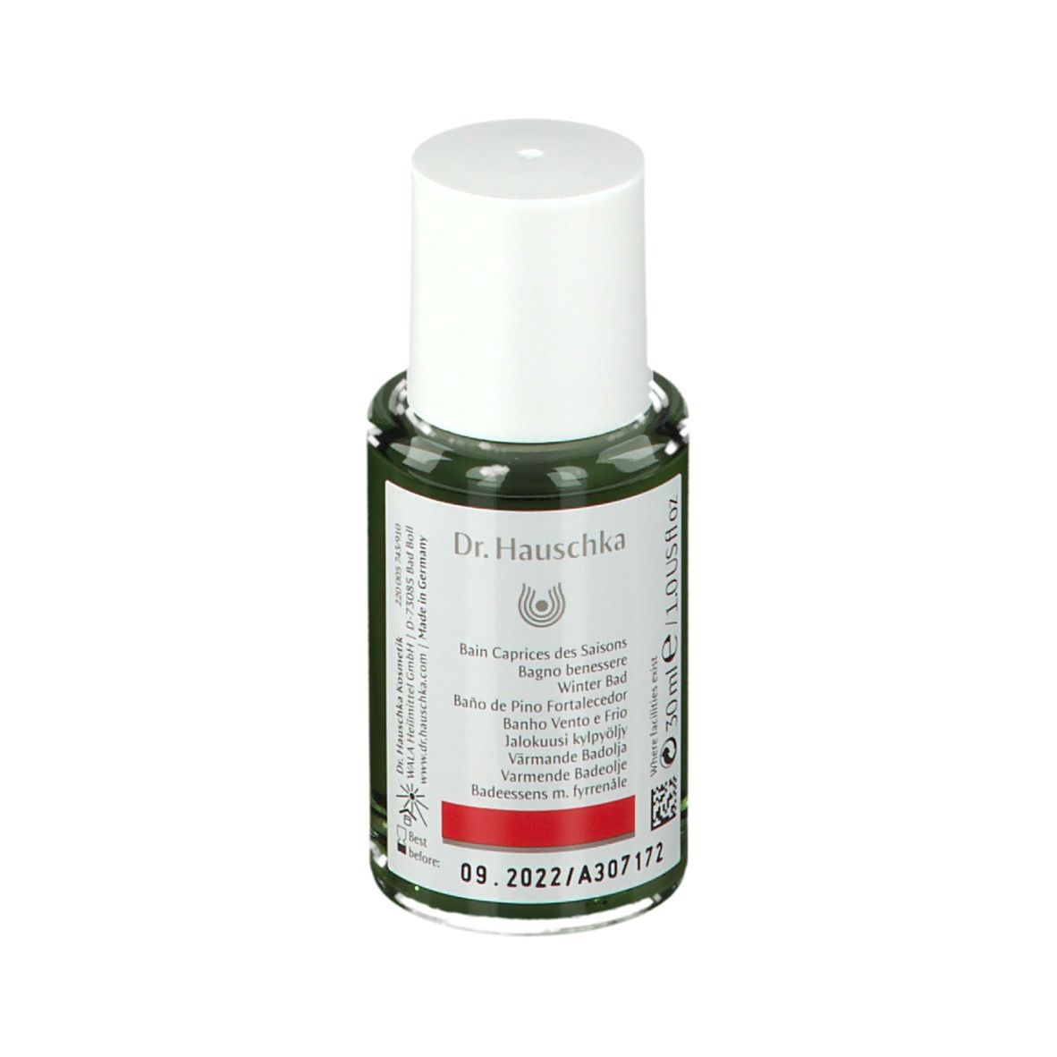 Flacone di vetro verde con tappo bianco. Etichetta con logo Dr. Hauschka e testo: Wind und Wetter Bad, Spruce Warming Bath Essence.