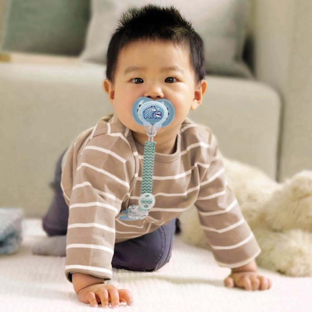 Bambino con ciuccio e clip